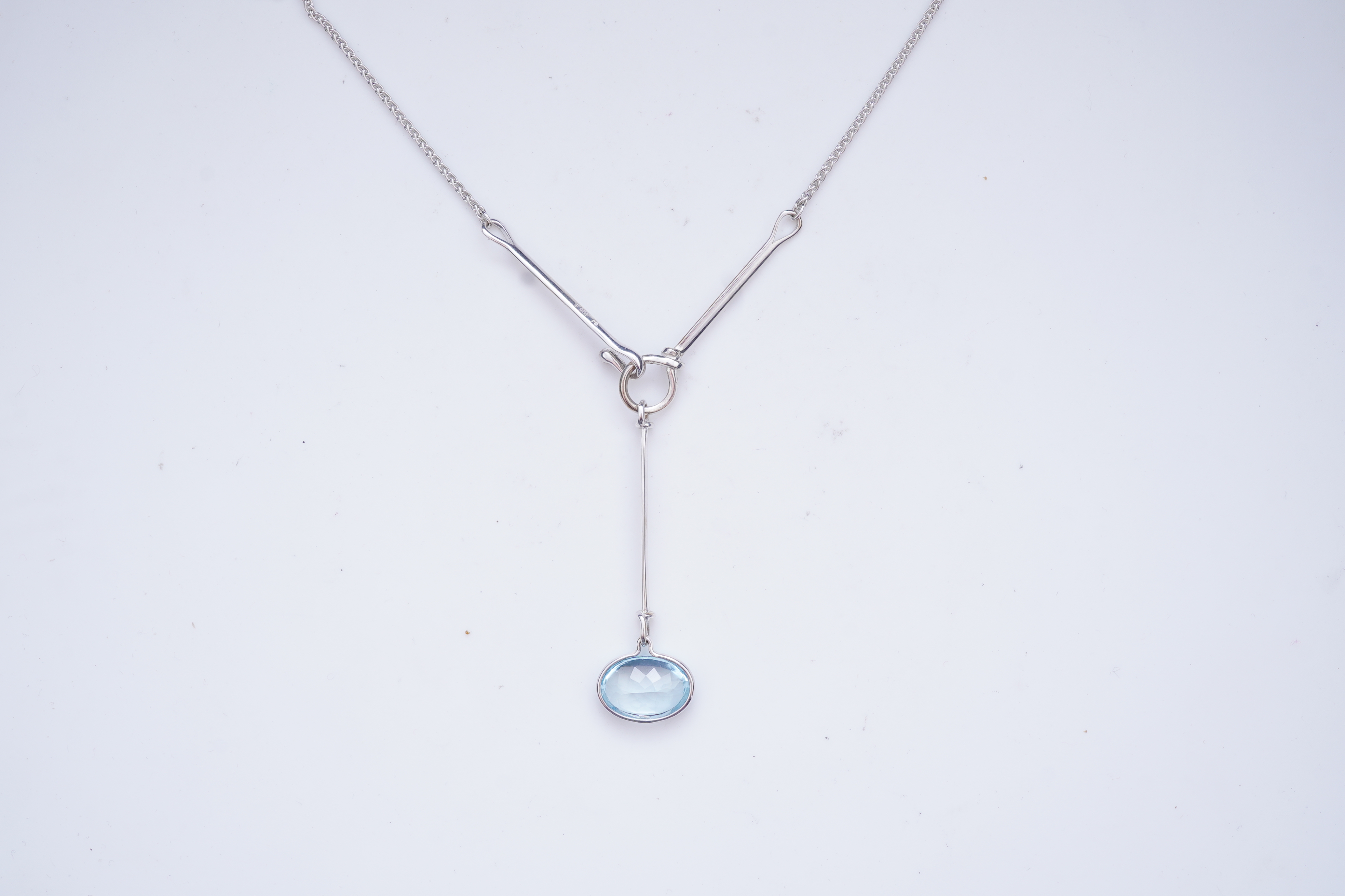 Georg Jensen, a blue topaz necklace, centring on a hook clasp suspending an oval blue topaz pendant, pendant length 5.5cm, necklace length 43cm, stamped GJ for Georg Jensen, 925S and European convention assay marks for s